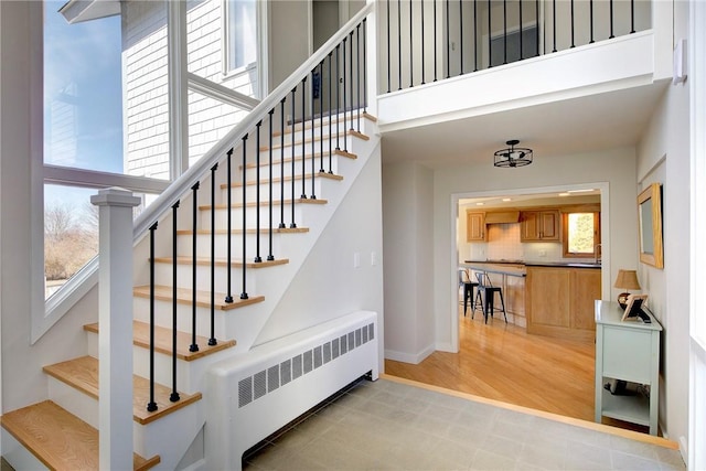 stairs featuring baseboards and radiator heating unit