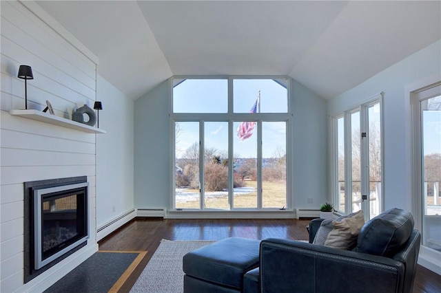 living room featuring dark wood finished floors, vaulted ceiling, a baseboard heating unit, and a fireplace with flush hearth