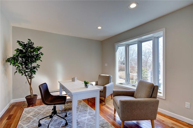 office area with baseboards, a wealth of natural light, and light wood finished floors