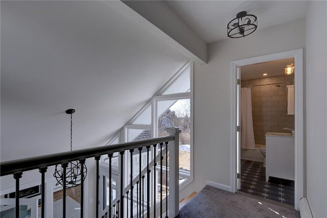 hall featuring baseboards, a baseboard radiator, and carpet
