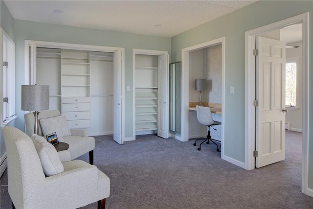 sitting room featuring carpet flooring and baseboards