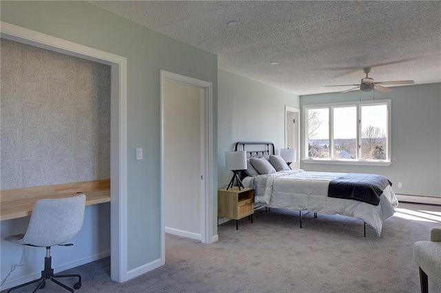 bedroom with carpet floors, a textured ceiling, baseboards, and a baseboard radiator