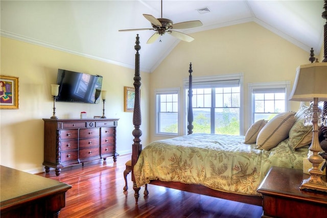 bedroom featuring vaulted ceiling, multiple windows, wood finished floors, and visible vents