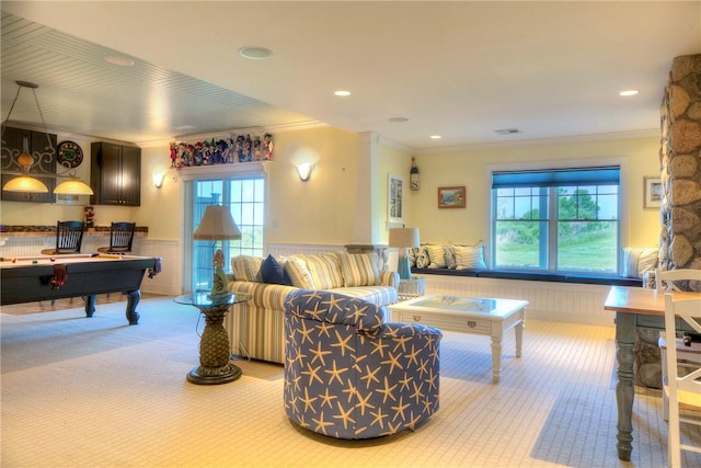 interior space with crown molding, carpet, plenty of natural light, and a wainscoted wall