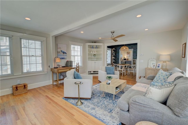 living room with a ceiling fan, baseboards, recessed lighting, and wood finished floors