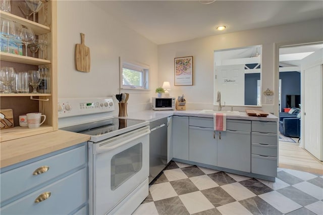 kitchen featuring white appliances, gray cabinetry, a sink, and light countertops