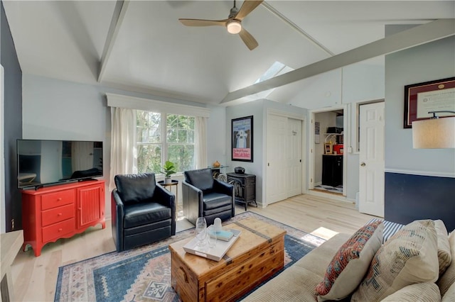 living room featuring a ceiling fan, wood finished floors, and vaulted ceiling
