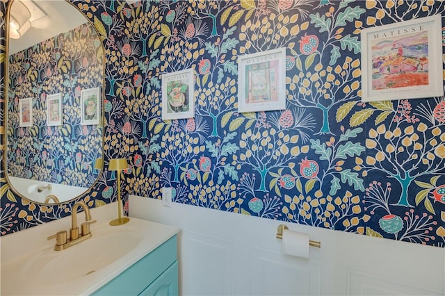 bathroom with wallpapered walls and vanity