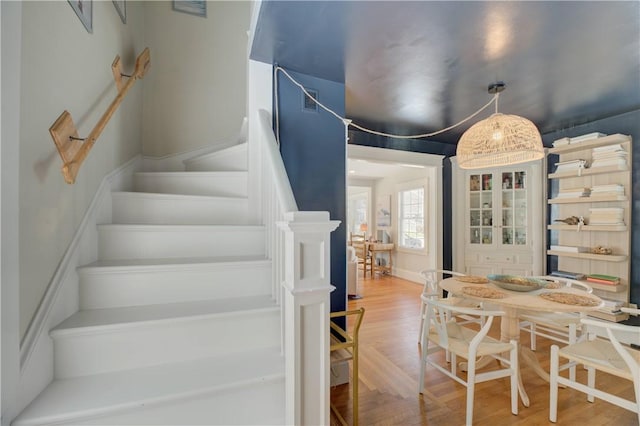 dining area featuring wood finished floors and stairway