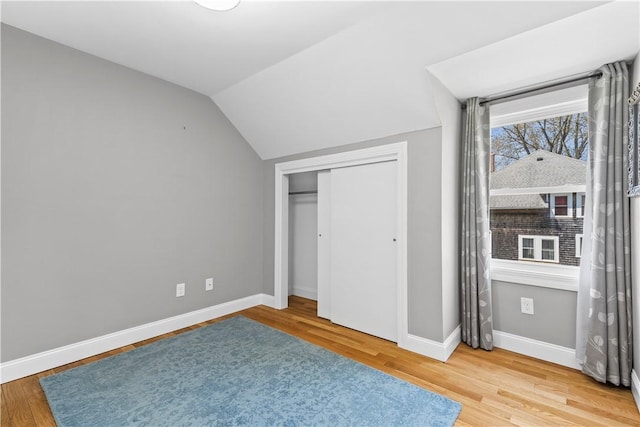 120 Columbia Heights Rd Unit 1, Charlestown, RI 02813 - unfurnished bedroom featuring a closet, baseboards, vaulted ceiling, and wood finished floors