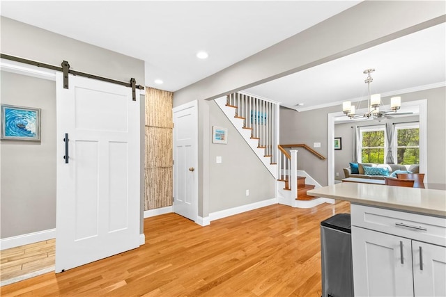 120 Columbia Heights Rd Unit 1, Charlestown, RI 02813 - kitchen featuring a barn door, light countertops, baseboards, an inviting chandelier, and light wood-style flooring