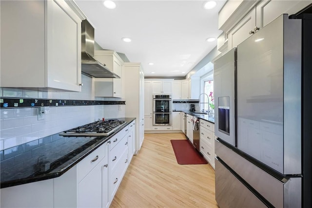 170 Summit Dr, Cranston, RI 02920 - kitchen with a sink, white cabinetry, decorative backsplash, wall chimney exhaust hood, and appliances with stainless steel finishes