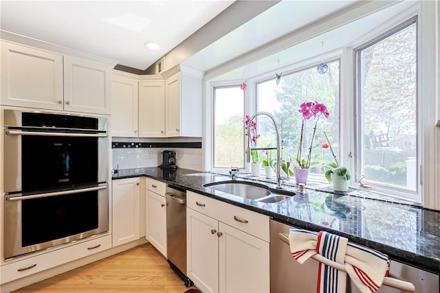 170 Summit Dr, Cranston, RI 02920 - kitchen featuring a sink, tasteful backsplash, dark stone countertops, stainless steel double oven, and white cabinetry