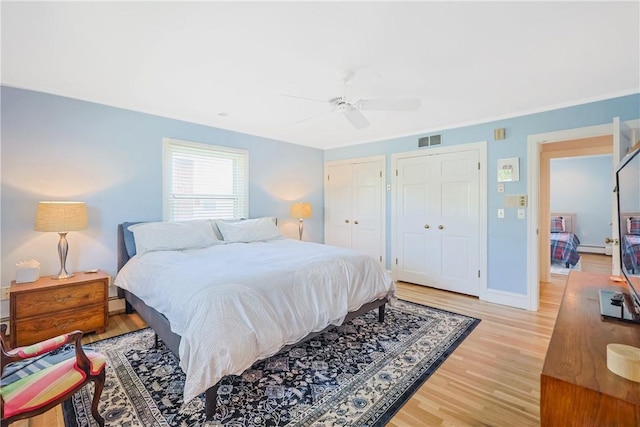170 Summit Dr, Cranston, RI 02920 - bedroom with two closets, light wood-style flooring, a ceiling fan, and visible vents