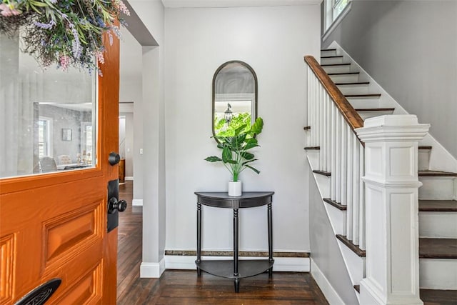 entrance foyer featuring baseboards, dark wood-style floors, and stairs