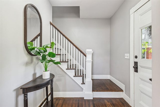 entrance foyer featuring baseboards, stairs, and wood finished floors