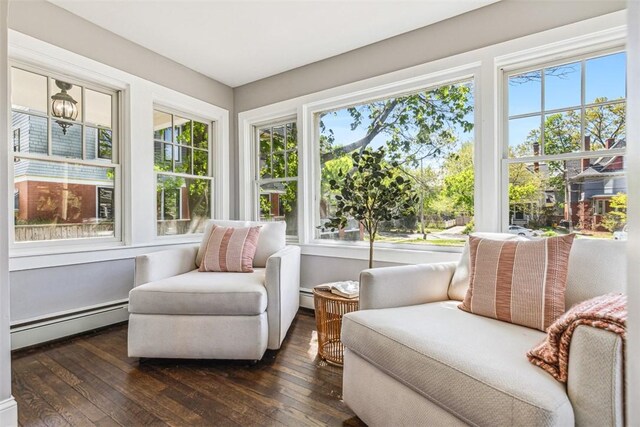 sunroom featuring plenty of natural light, baseboard heating, and hardwood / wood-style floors