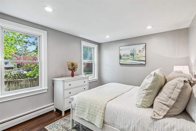 bedroom with a baseboard radiator, multiple windows, recessed lighting, and dark wood-type flooring