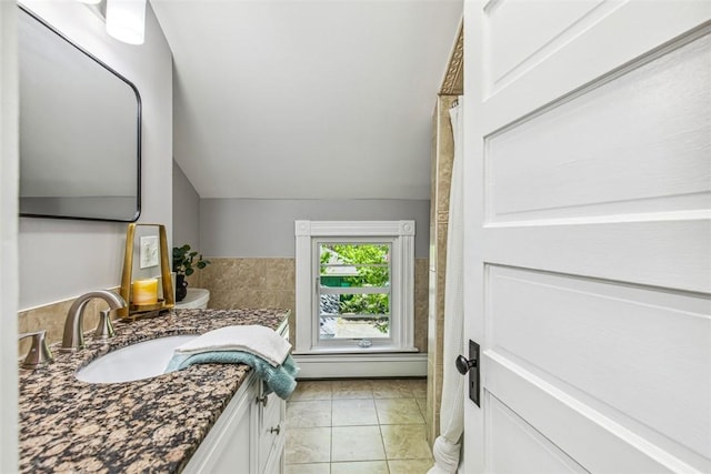 full bathroom featuring vanity, a baseboard heating unit, and lofted ceiling