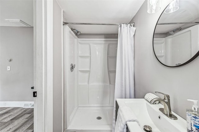 bathroom featuring a sink, a stall shower, and wood finished floors