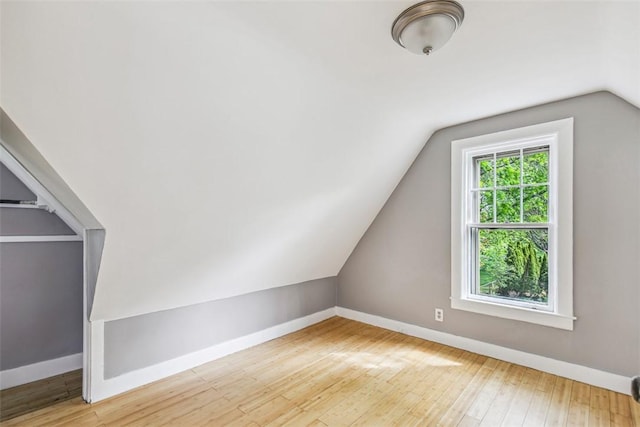 bonus room with baseboards, wood finished floors, and lofted ceiling