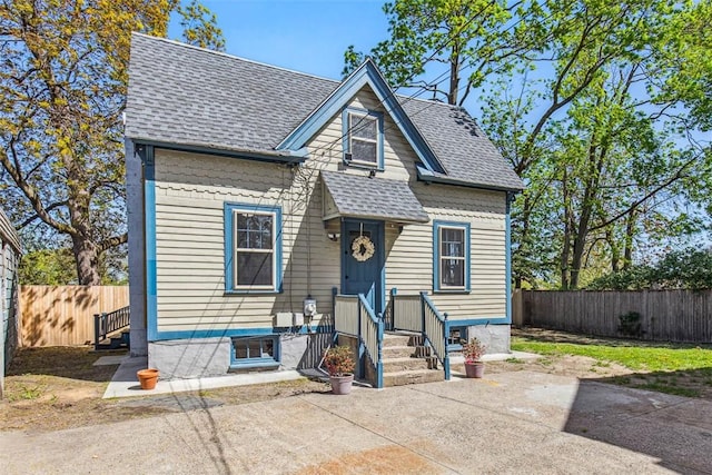 bungalow with roof with shingles, a patio, and a fenced backyard