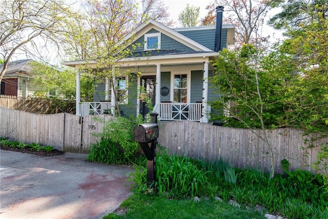 bungalow-style home with a porch and a fenced front yard