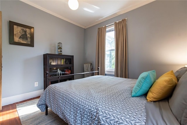 bedroom featuring crown molding and wood finished floors