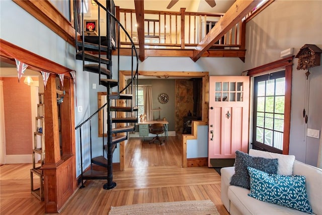 living area with stairway, baseboards, plenty of natural light, and wood finished floors