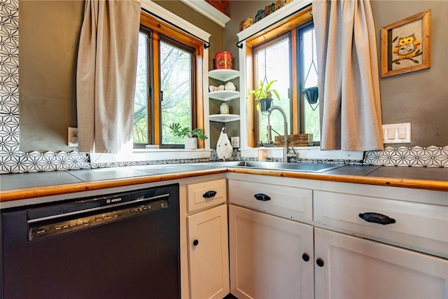 kitchen featuring white cabinets, a sink, and dishwasher