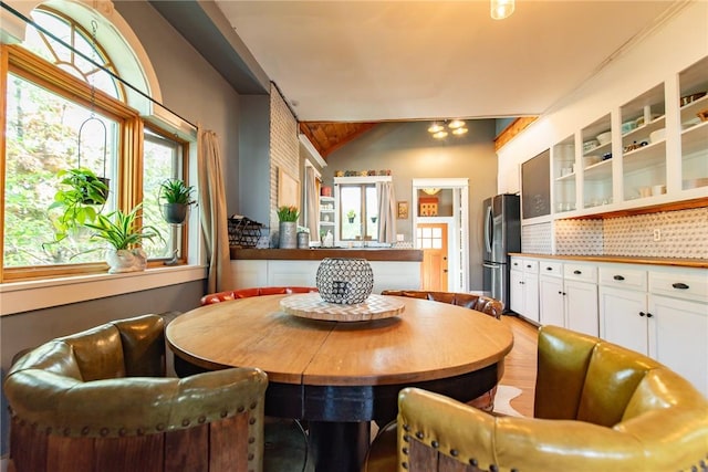 dining space with vaulted ceiling and wood finished floors
