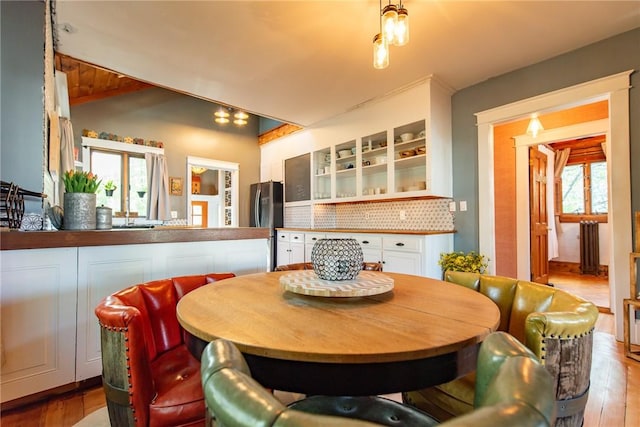 dining area featuring vaulted ceiling with beams and wood finished floors