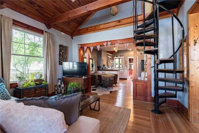 living area with lofted ceiling with beams, wood ceiling, light wood finished floors, and stairs