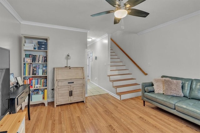 sitting room featuring crown molding, ceiling fan, and stairway
