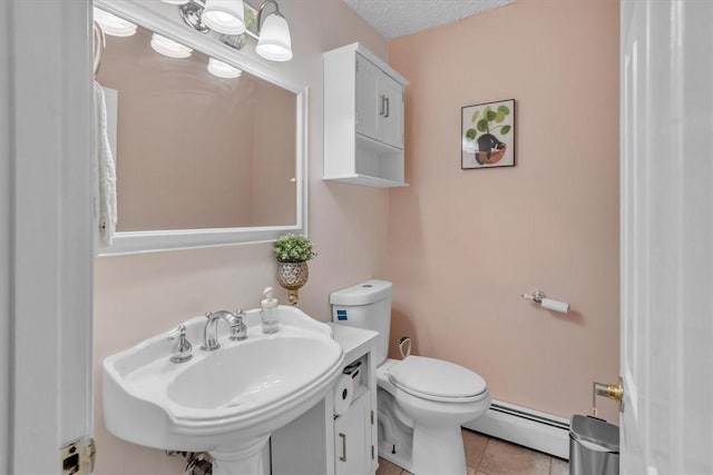 half bath with a textured ceiling, tile patterned flooring, a sink, a baseboard radiator, and toilet
