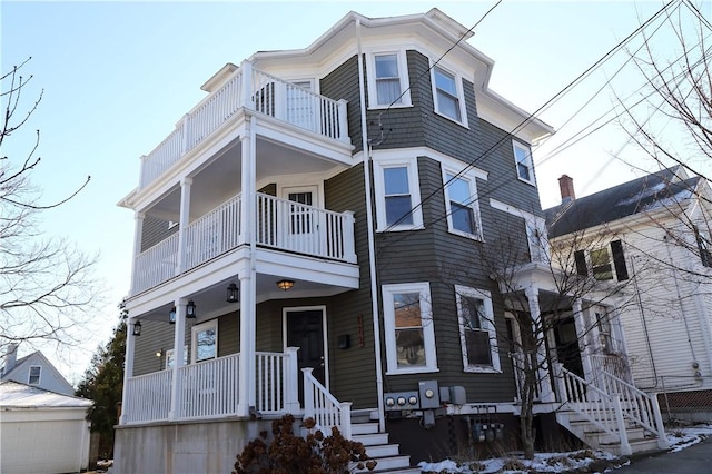 view of front of property with an outbuilding, a porch, and a balcony