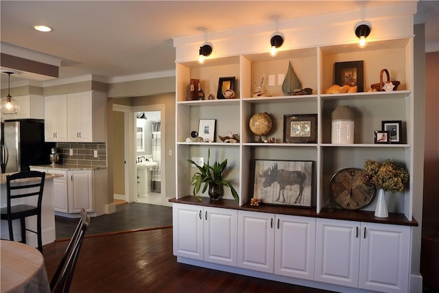 interior space featuring freestanding refrigerator, decorative backsplash, open shelves, dark wood-type flooring, and white cabinetry