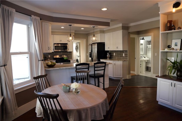 dining area with crown molding, recessed lighting, dark wood-style flooring, and stacked washer / dryer