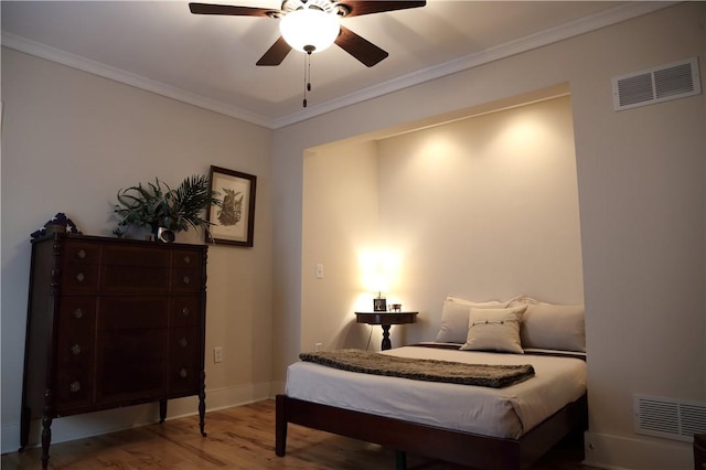 bedroom featuring baseboards, visible vents, ornamental molding, and wood finished floors