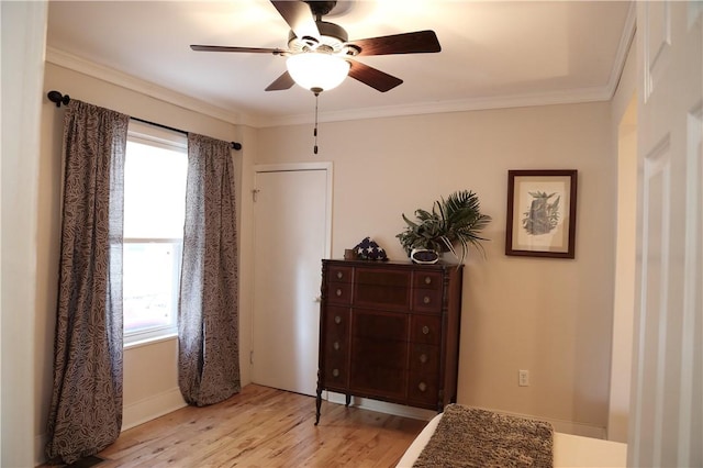 bedroom featuring crown molding, multiple windows, and light wood-type flooring