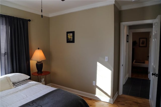 bedroom featuring crown molding, baseboards, and wood finished floors
