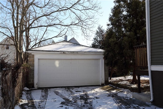 snow covered garage featuring a detached garage