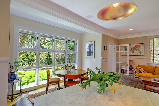 interior space featuring visible vents, wainscoting, crown molding, and wood finished floors