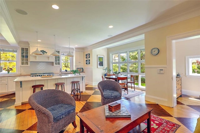 living room with crown molding, recessed lighting, baseboards, and light wood finished floors