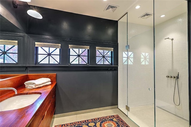 bathroom with vanity, tile patterned floors, a tile shower, and visible vents