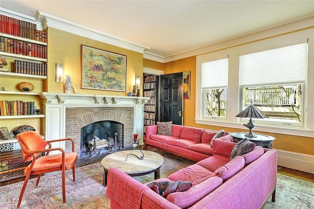 living room featuring crown molding, a brick fireplace, built in shelves, wood finished floors, and baseboards