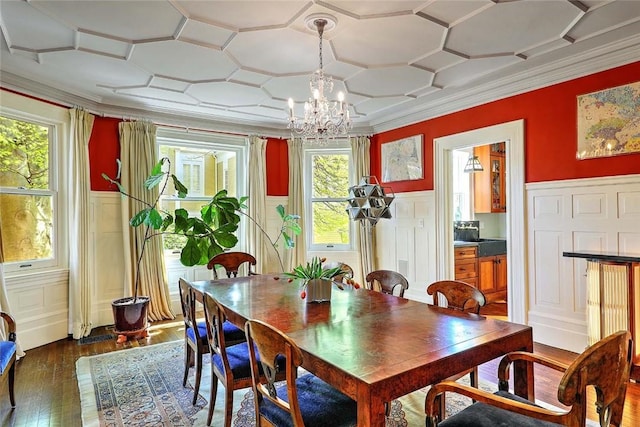 dining space with ornamental molding, a chandelier, a wealth of natural light, and dark wood-style floors