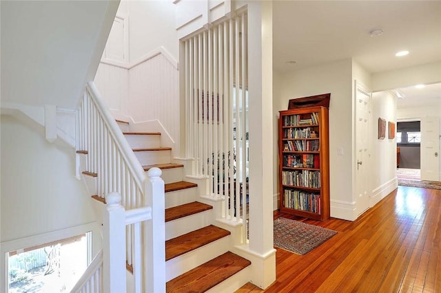 staircase featuring baseboards, recessed lighting, and hardwood / wood-style floors