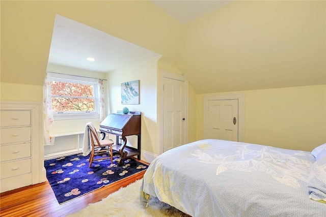bedroom with wood finished floors and vaulted ceiling