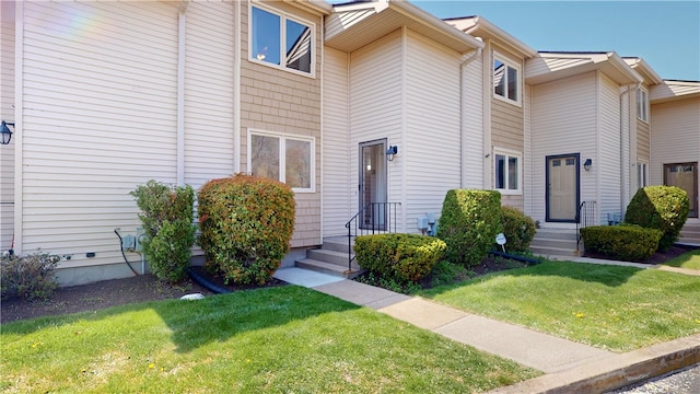 property entrance with a lawn